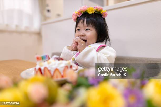 彼女の最初の誕生日のための女の赤ちゃんのスマッシングケーキ - smash cake ストックフォトと画像