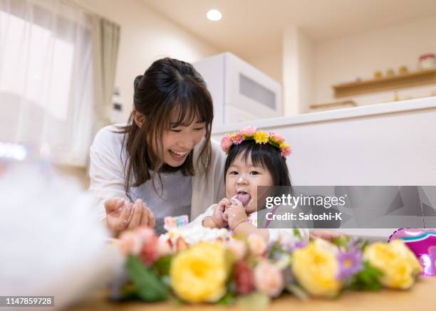 baby girl smashing cake for her first birthday - cake smashing stock pictures, royalty-free photos & images