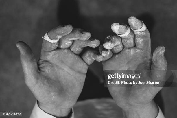 a man's battered rock climbing hands - chalk rock stock-fotos und bilder