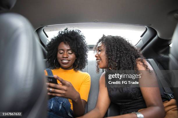 mulheres afro novas que têm durante uma viagem de estrada no carro - friends inside car - fotografias e filmes do acervo