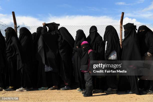 Wives and childern of former ISIS fighters line up in the foreign section of the al-Hawl refugee camp in northern Syria, waiting to be taken to the...