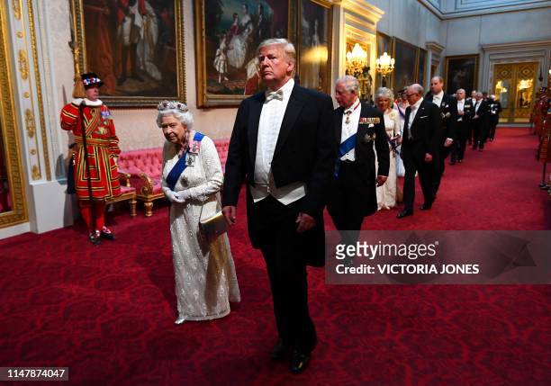 Britain's Queen Elizabeth II walks with US President Donald Trump and other guests as they arrive through the East Gallery during a State Banquet in...