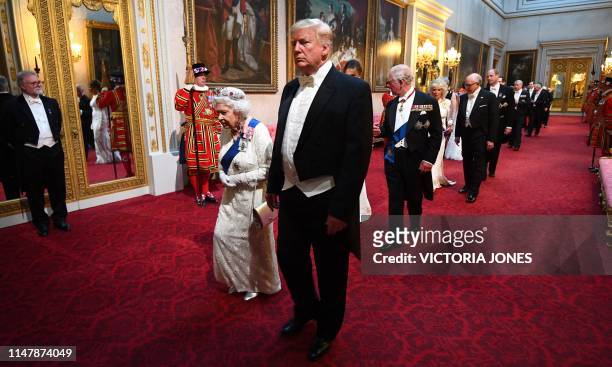 Britain's Queen Elizabeth II walks with US President Donald Trump and other guests as they arrive through the East Gallery during a State Banquet in...