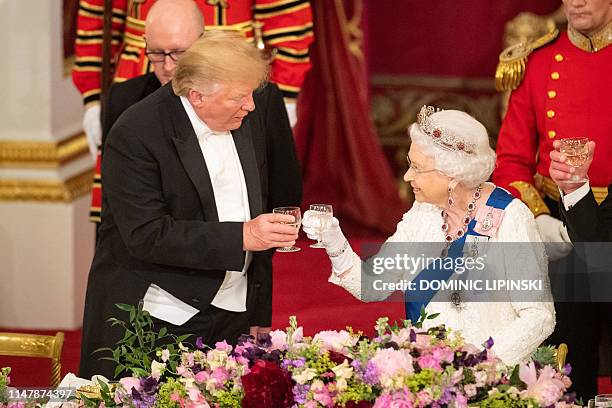 Britain's Queen Elizabeth II raises a glasses with US President Donald Trump during a State Banquet in the ballroom at Buckingham Palace in central...