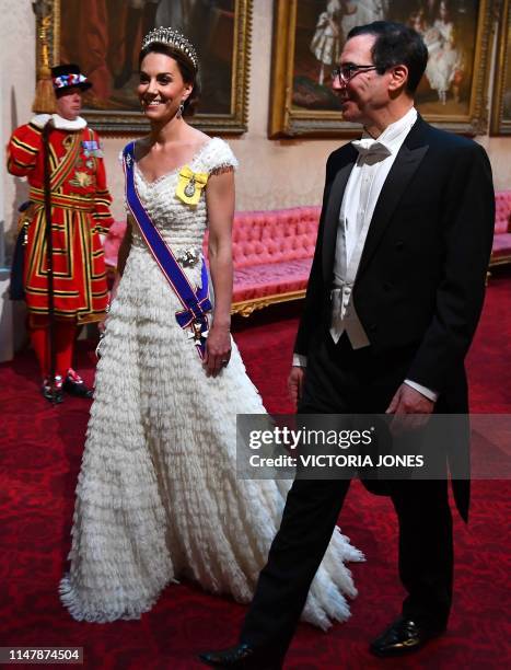 Britain's Catherine, Duchess of Cambridge walks with US Secretary of Treasury Steven Mnuchin as they arrive through the East Gallery during a State...