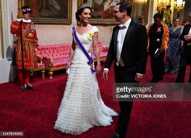 Britain's Catherine, Duchess of Cambridge walks with US Secretary of Treasury Steven Mnuchin as they arrive through the East Gallery during a State...