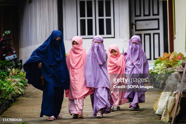Young girls from the Islamic commune An-Nadzir walk to attend Eid Al Fitr at Baitul Muqaddis mosque in Gowa, South Sulawesi Province. An-Nadzir is an...