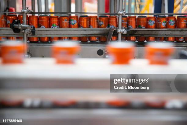 Cans of Coca-Cola Co. Brand Fanta carbonated soft drink move along a conveyor at the Coca-Cola Cambodia Bottling Plant, operated by Cambodia Beverage...