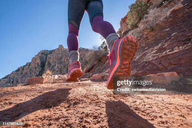 lage hoekmening van vrouwen parcours dat in stoffige berg in de woestijn loopt; mensen sport buitenshuis concept - arizona mountains stockfoto's en -beelden