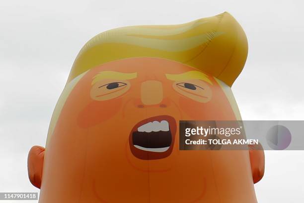 Giant balloon depicting US President Donald Trump as an orange baby floats above anti-Trump demonstrators in Parliament Square outside the Houses of...