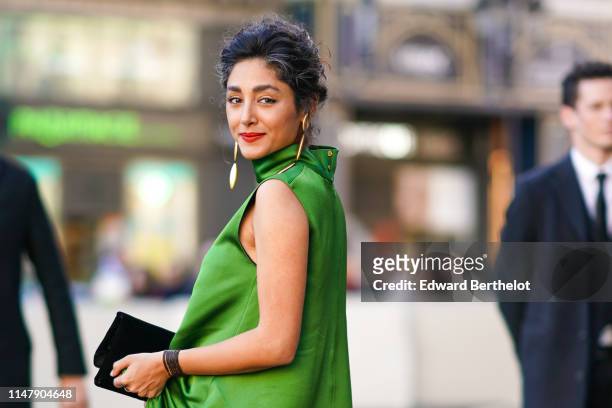 Golshifteh Farahani wears a green dress, a clutch, earrings, red lipstick, outside the Opera Garnier 350th Anniversary Gala in Paris on May 08, 2019...