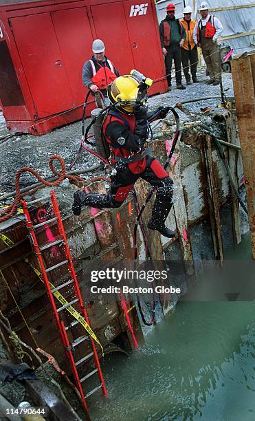 Robbie Smith, a construction scuba diver from Buffalo, NY, leaps into the waters of the Fort Point Channel, where he will work for three hours in...