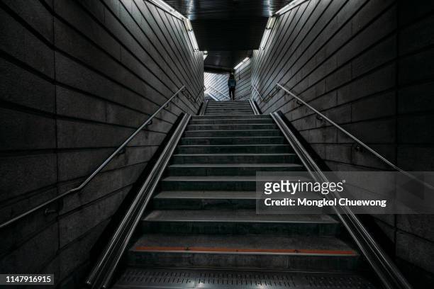 young woman traveler walking into the light in the dark tunnel from underground at seoul city in south korea - dark street stock pictures, royalty-free photos & images