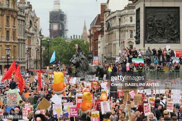 Anti-Trump protesters hold placards and balloons depicting US President Donald Trump as an orange baby as they gather in Trafalgar Square during a...