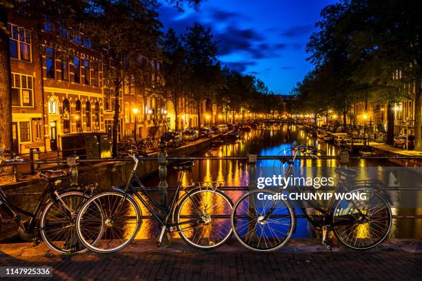 amsterdam bei nacht, niederlande. - fluss amstel stock-fotos und bilder