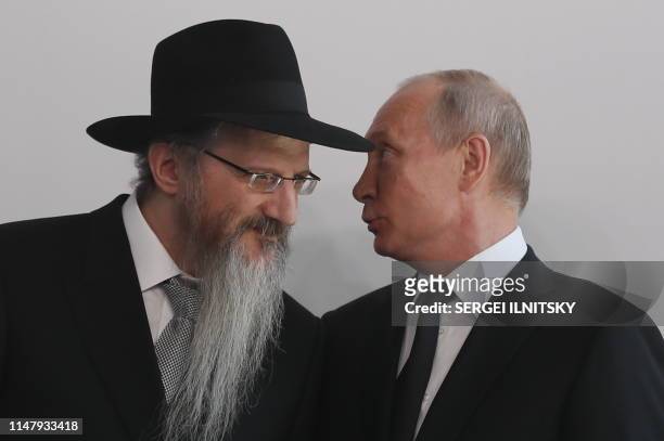 Russian President Vladimir Putin speaks with Chief Rabbi of Russia Berel Lazar during a ceremony unveiling the memorial to members of the resistance...