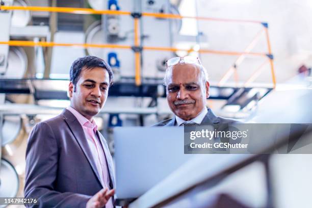 senior businessman reviewing production reports with his factory manager - entrepreneur manufacturing stock pictures, royalty-free photos & images