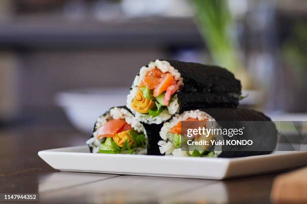 rollo de arroz envuelto en un plato. - roll fotografías e imágenes de stock