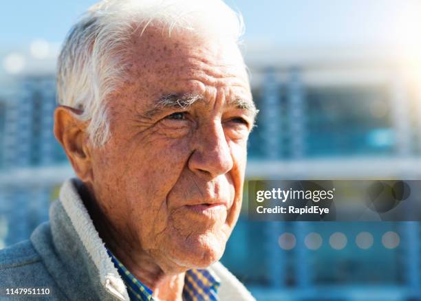 senior man standing in bright sunlight outside building - liver spot stock pictures, royalty-free photos & images