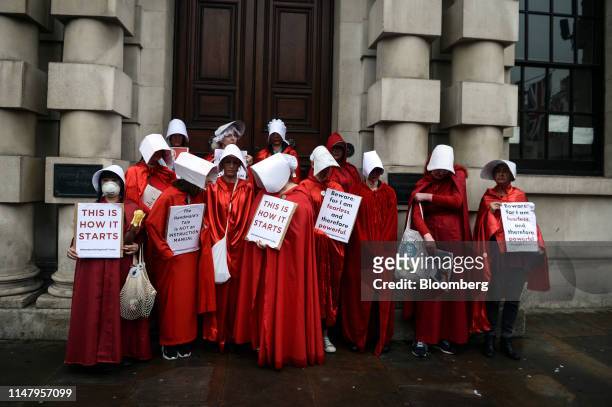 Demonstrators dressed in "Handmaid's Tale" costumes hold anti-Trump placards during a demonstration in London, U.K., on Tuesday, June 4, 2019. With...
