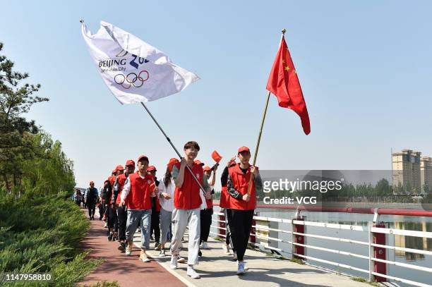 University student volunteers hold a Chinese national flag and a flag reading 'Beijing 2022' to welcome the 1,000-day countdown to 2022 Winter...