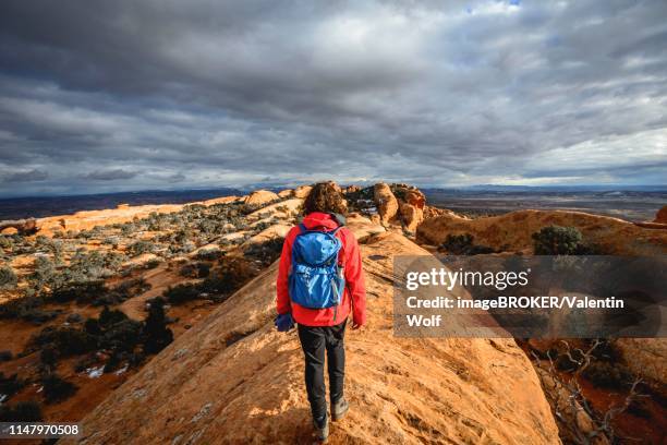 tourist, young woman hiking on sandstone cliffs, devil's garden trail, arches national park, utah, usa - devil's garden arches national park stock pictures, royalty-free photos & images