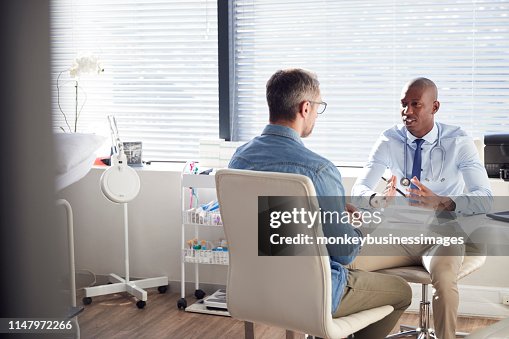 Mature Male Patient In Consultation With Doctor In Office Mature Male Patient In Consultation With Doctor In Office