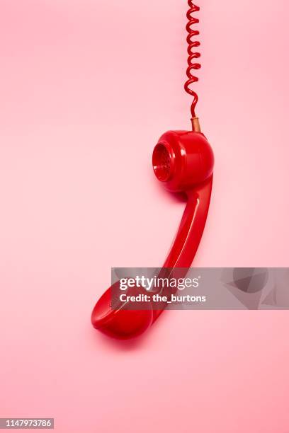 high angle view of a red old-fashoined phone on pink background, retro telephone receiver - telephone old stock-fotos und bilder