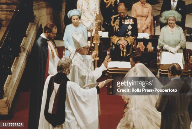 In front of Queen Elizabeth II, Prince Philip and Queen Elizabeth the Queen Mother, Prince Charles and Diana Spencer are blessed by Archbishop of...
