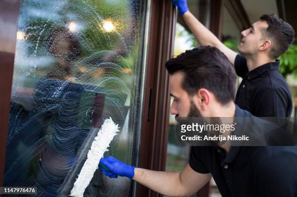 limpiador de ventanas en su trabajo - limpieza profesional fotografías e imágenes de stock