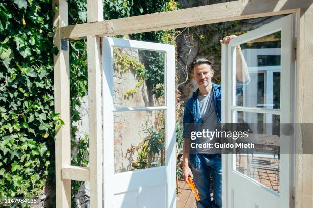 smiling happy man with his diy greenhouse project. - smart glass stock-fotos und bilder