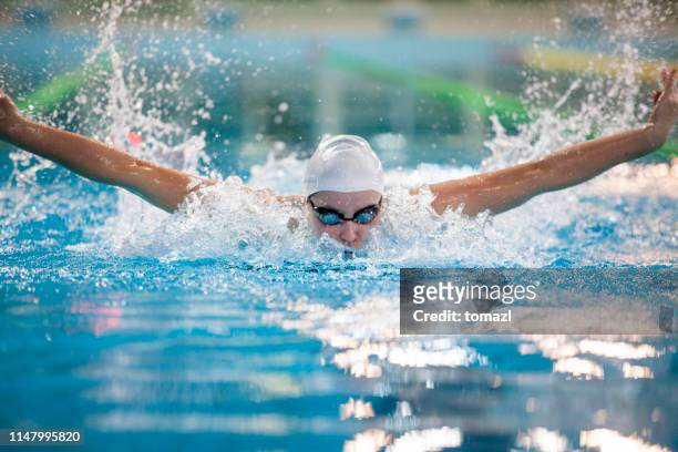nadadora femenina-carrera de mariposa - torneo de natación fotografías e imágenes de stock