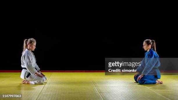 jonge judo spelers knielend op mat - asian indoor & martial arts games stockfoto's en -beelden