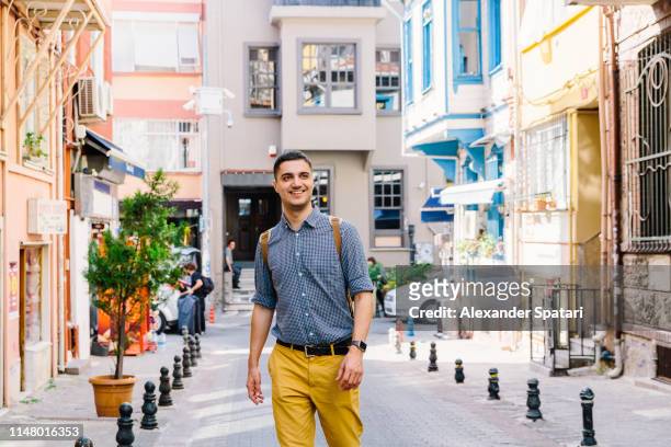 young smiling happy man walking on the street in istanbul, turkey - daily life in istanbul stock-fotos und bilder