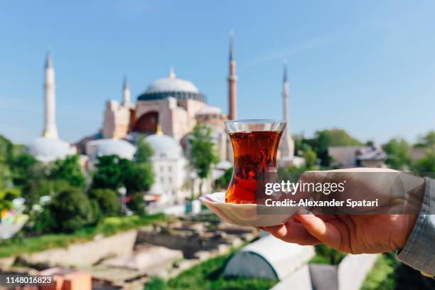 drinking turkish tea with view of hagia sophia in the background - türkei tee stock-fotos und bilder