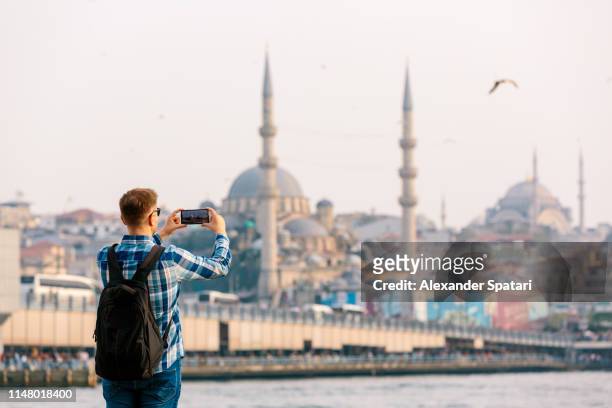 tourist photographing istanbul skyline with smart phone, rear view - istanbul bildbanksfoton och bilder