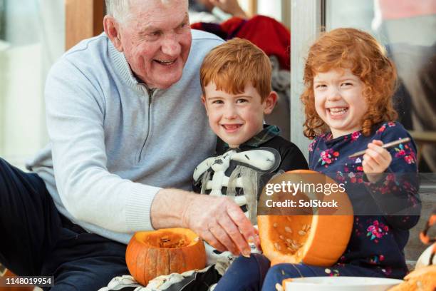 portrait of children while carving pumpkins - heritage festival presented stock pictures, royalty-free photos & images