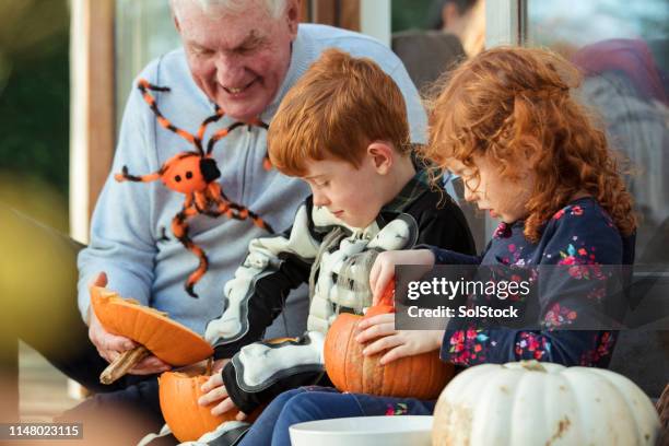 carving pumpkins with grandad - heritage festival presented stock pictures, royalty-free photos & images