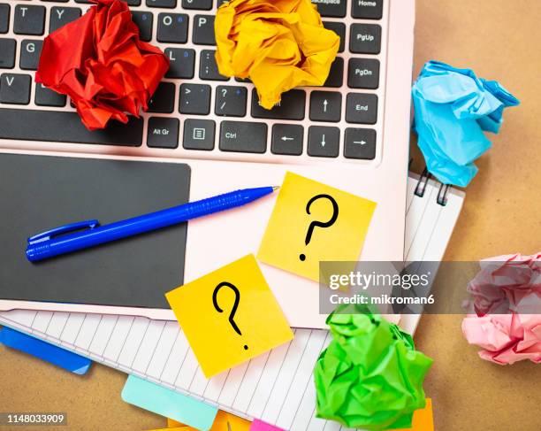 office work with laptop and sticky notes with question mark - sticky note pad stock pictures, royalty-free photos & images