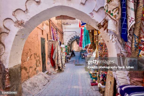 walking though the souks in marrakech's medina - marrakesh stockfoto's en -beelden