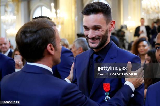 French president Emmanuel Macron embraces France's team captain Hugo Lloris during a ceremony to award French 2018 football World Cup winners with...