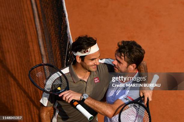 Switzerland's Roger Federer hugs Switzerland's Stanislas Wawrinka after winning during their men's singles quarter-final match on day ten of The...