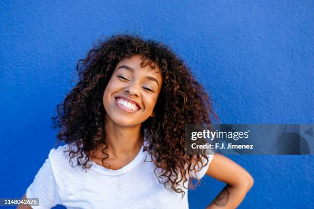 portrait of smiling woman with blue background - black woman happy white background foto e immagini stock