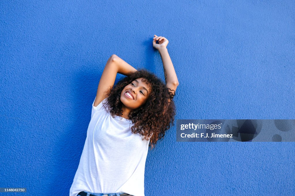 Portrait of smiling woman with blue background