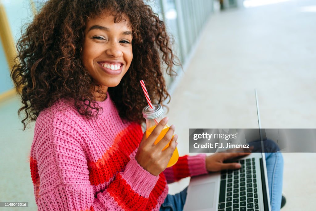 Portrait of smiling woman with laptop and juice