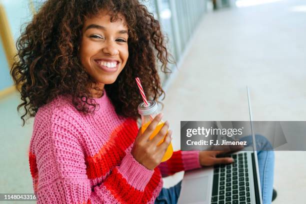 portrait of smiling woman with laptop and juice - generation z laptop stock pictures, royalty-free photos & images