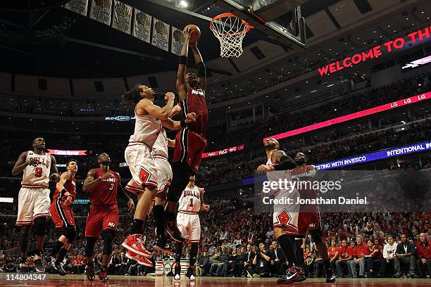 Chris Bosh of the Miami Heat dunks against Joakim Noah and Carlos Boozer of the Chicago Bulls in Game Five of the Eastern Conference Finals during...