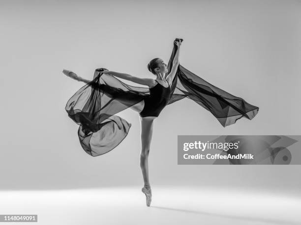 joven hermosa bailarina bailando sobre fondo gris - bailarín fotografías e imágenes de stock