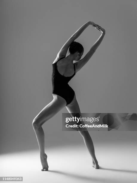 junge schöne tänzerin tanzt auf grauem hintergrund - ballet dancers russia stock-fotos und bilder
