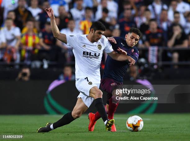 Goncalo Guedes of Valencia passes the ball under pressure from Lucas Torreira of Arsenal during the UEFA Europa League Semi Final Second Leg match...